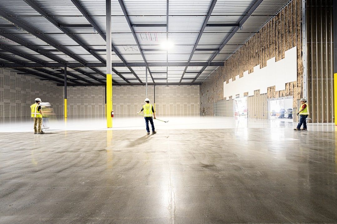Workers inspecting a spacious warehouse floor during construction