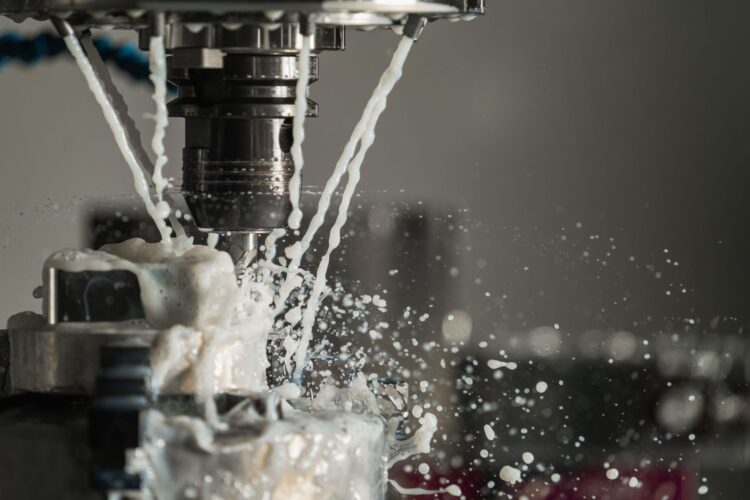 CNC cutting tool machining a metal part amid splashing coolant